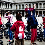 Venice - Boys playing with pigeons in St. Mark's square, color photo