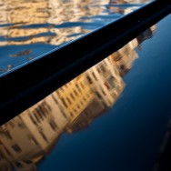 Venice - reflections of Grand Canal palaces over the side of a gondola , color landscape photo