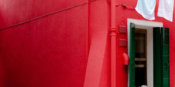 Venice - red colorful house in Burano island, color portrait photo