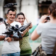 Venice - tourists photographed with pigeons in St. Mark's square, color landscape photo