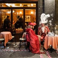 Venice - couple in carnival costumes at a cafè in St. Mark's square